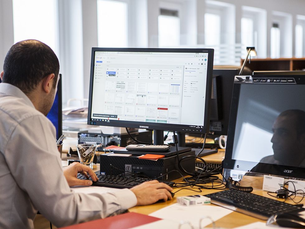 Employee working at a desktop computer with two monitors in an office